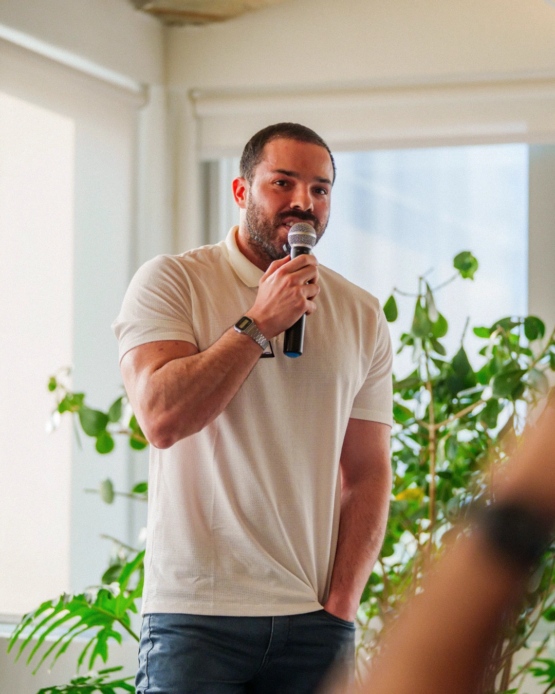 Samuel Sposito em pé, falando ao microfone durante o encontro do Montag Club.